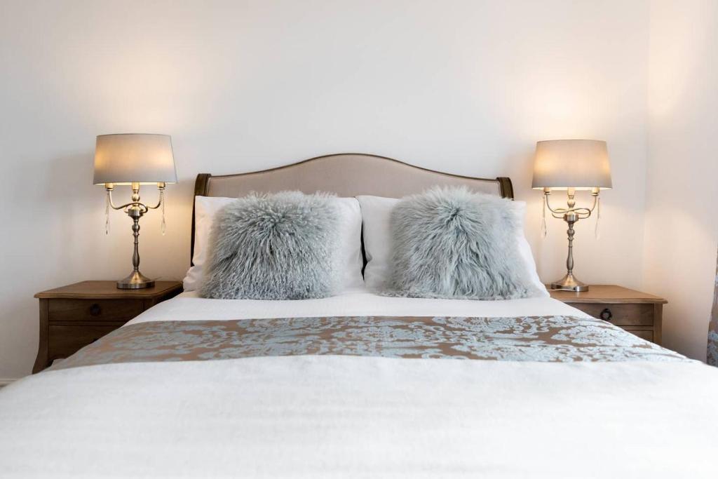 sypialnia z łóżkiem z poduszkami i 2 lampami w obiekcie The Bluebird - One Bedroom Apartment in Watford w mieście Watford