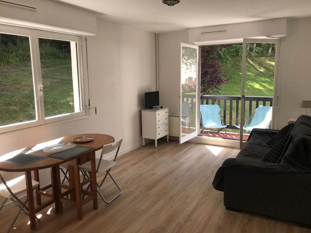 sala de estar con mesa y sofá en Entre forêt et Mer au Calme, en Trouville-sur-Mer