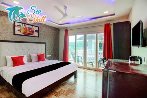 een slaapkamer met een bed met een zeezoutbord aan de muur bij Sea Shell Beach Cottages & Suites in Arambol