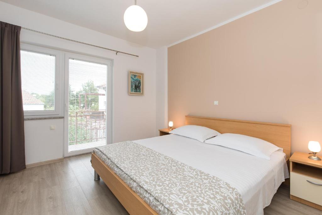 Postel nebo postele na pokoji v ubytování Apartments Laura