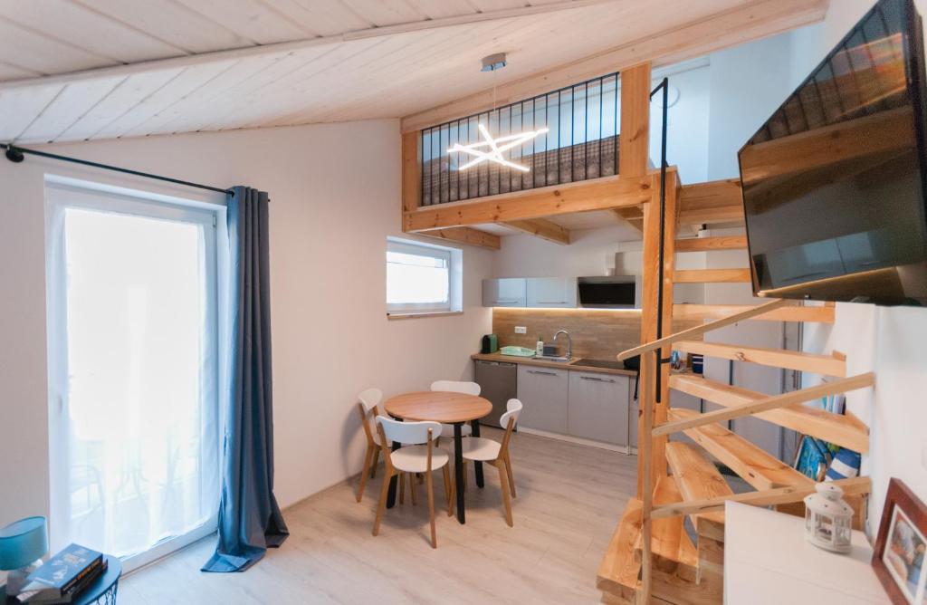 a tiny house with a spiral staircase and a kitchen at Matik Pokoje Goscinne in Karwia