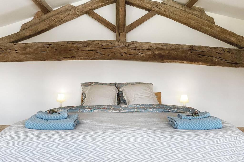 a bedroom with a large bed with two pillows at Maisonnette - LA CLOCHETTE in Lugon et l’Ile du Carney