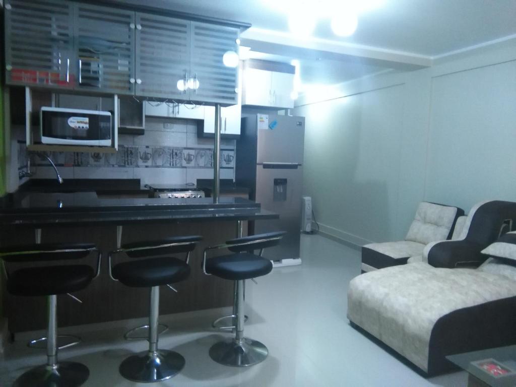 cocina con barra y sofá en una habitación en PYMABET, en Huancavelica