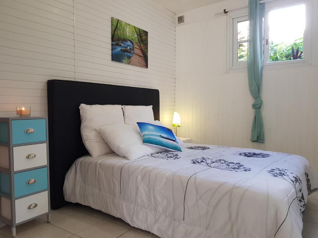 1 dormitorio con cama con almohada azul y mesita de noche en Chez Ena la fibre internet et le calme, en Saint-Claude