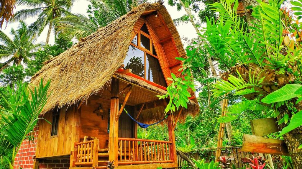 a thatch roofed house with a thatched roof at Tetebatu Sama Sama Bungalows in Tetebatu