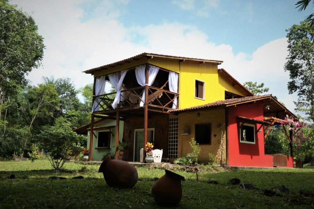 a house in the middle of a field at Sítio Pássaro Ímpar - Para pousar e repousar in Curuçá