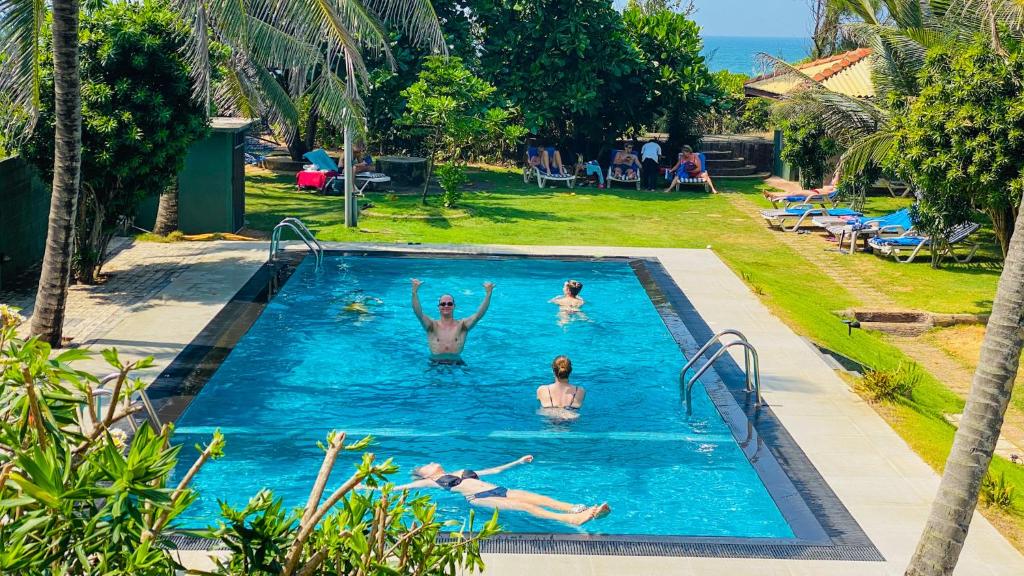 un groupe de personnes dans une piscine dans l'établissement Ziegler Cottage, à Negombo