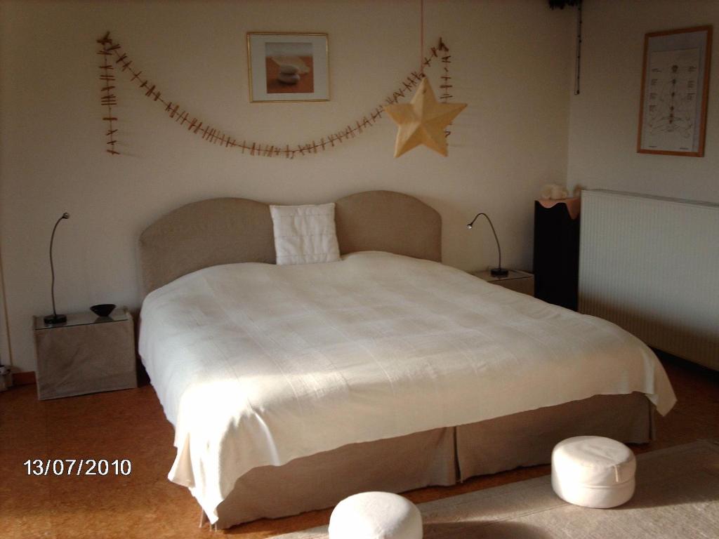 Un dormitorio con una cama grande con una estrella en la pared en B&B Koornemoezen, en Zedelgem