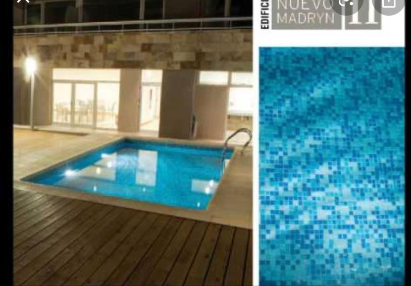 einen blauen Pool mit Holzboden in der Unterkunft La mansa in Puerto Madryn