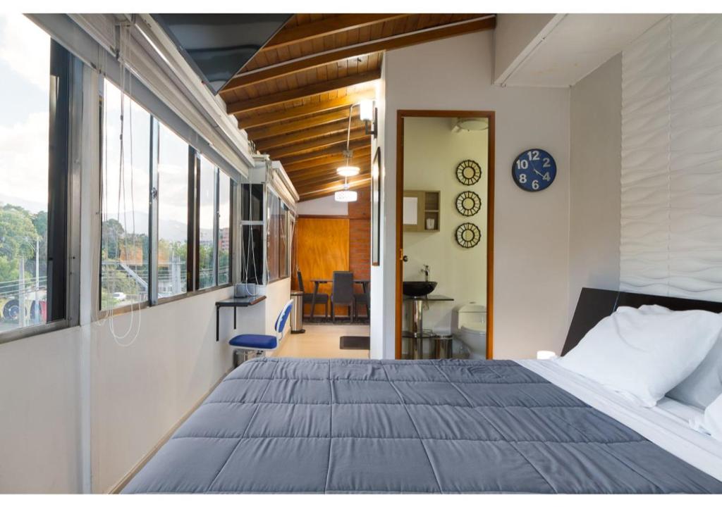 een slaapkamer met een groot bed in een kamer met ramen bij Studios Exito in Medellín