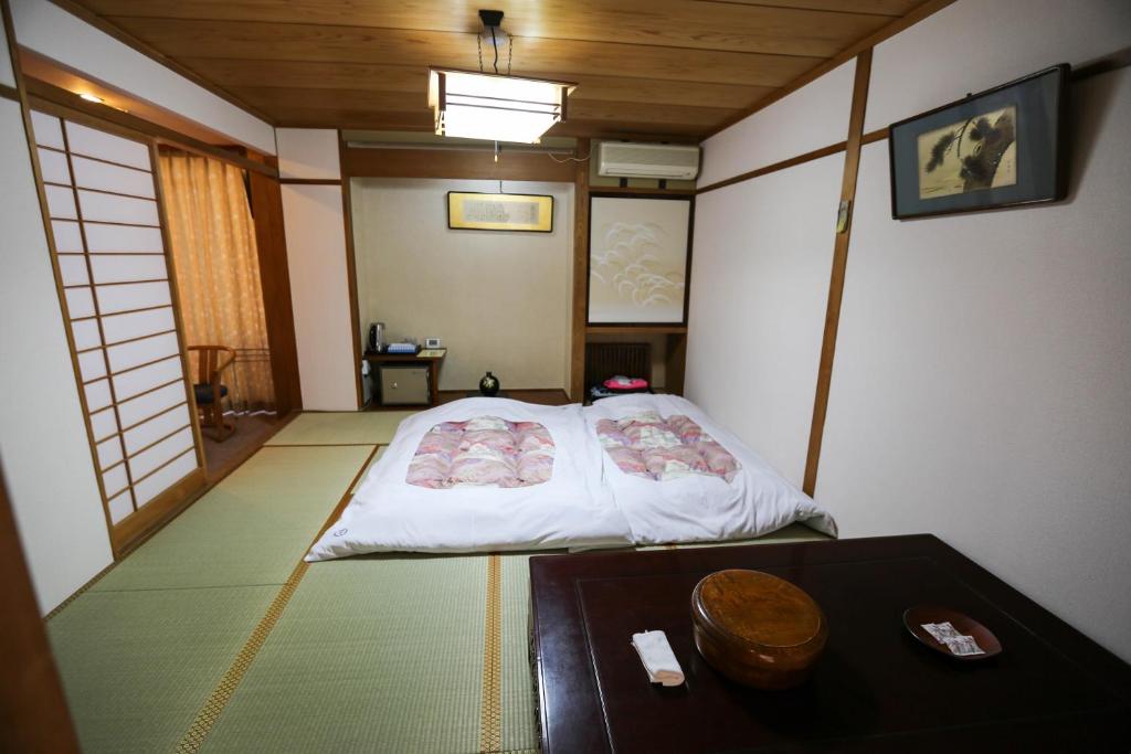 Postel nebo postele na pokoji v ubytování Rakki OnsenRyokan 楽奇温泉旅館