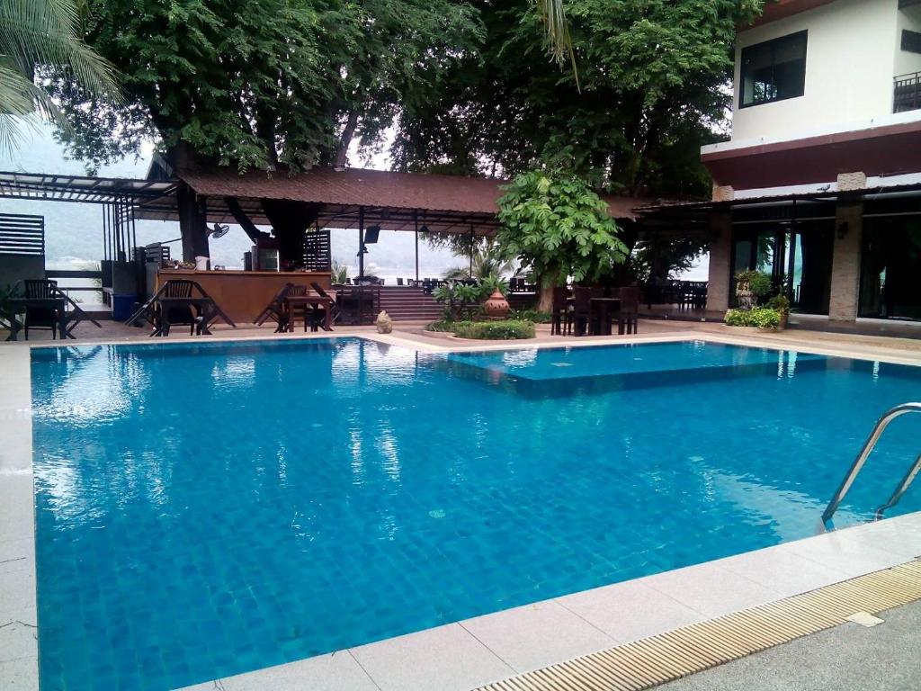 a large blue swimming pool in front of a building at Monsane River Kwai Resort & Spa in Kanchanaburi