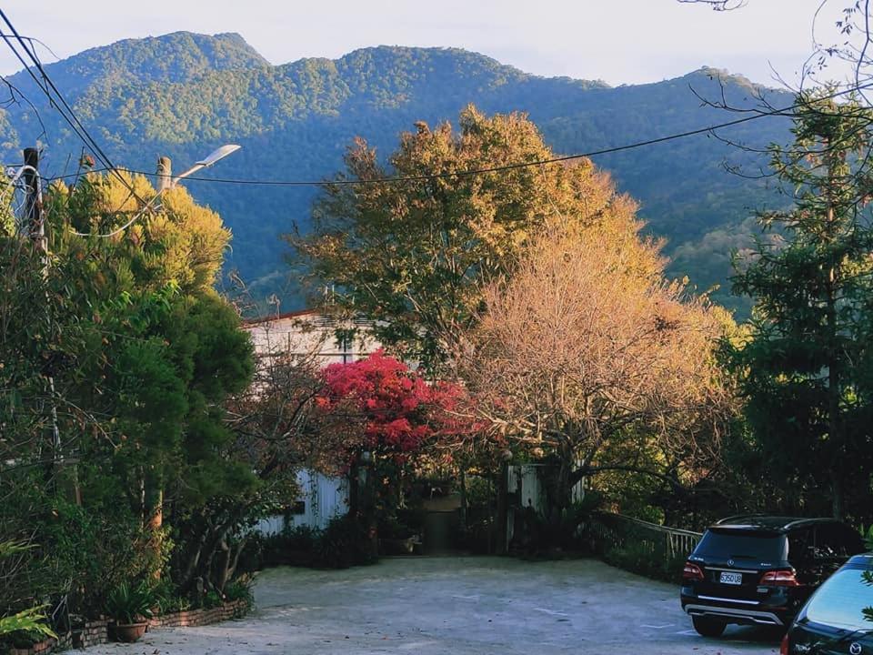 une voiture garée dans une allée avec des montagnes en arrière-plan dans l'établissement Shan Ju Lake Villa, à Renai