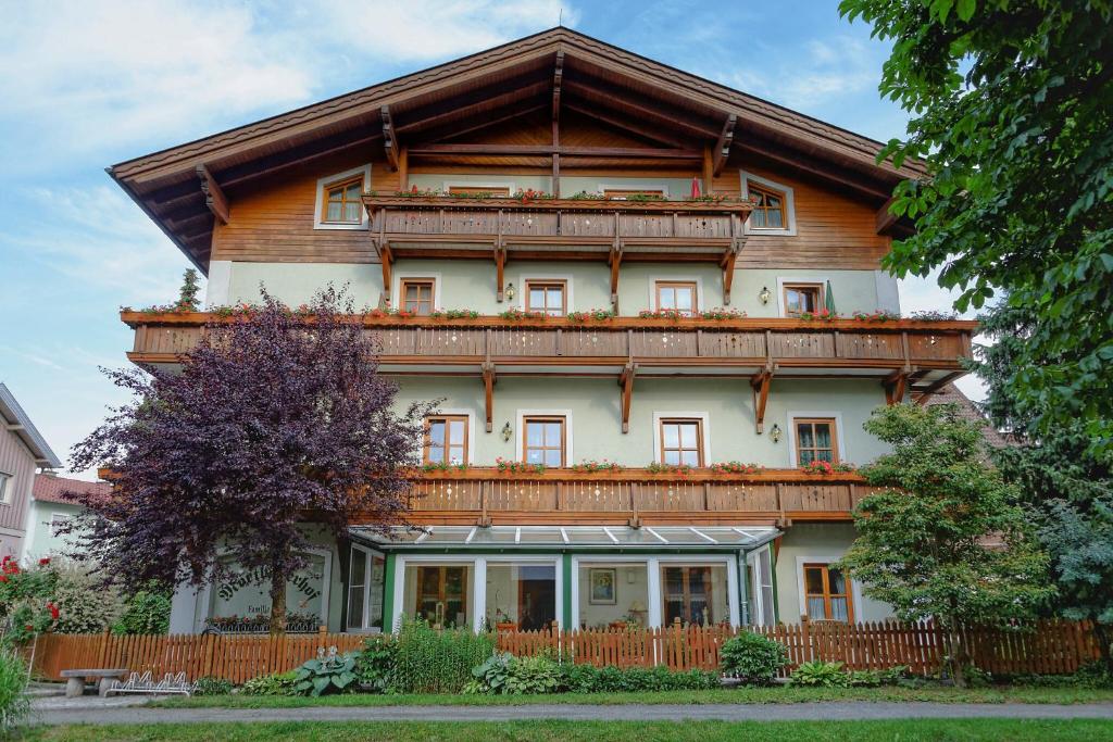 uma grande casa de madeira com um telhado de gambrel em Mörtbauerhof & Haus Frühauf em Seeboden