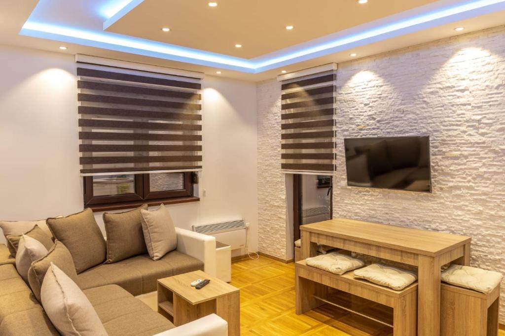 a living room with a couch and a tv at Apartments Mikic Zlatibor in Zlatibor