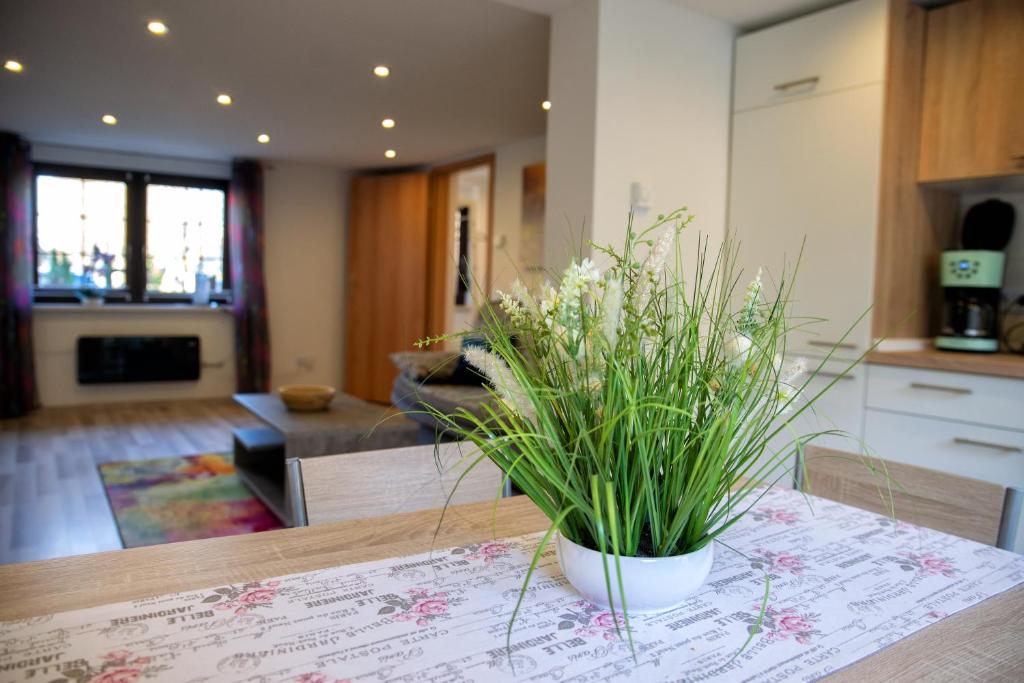 uma sala de estar com uma mesa com um vaso de plantas em Ferienhaus am Reiterhof em Templin