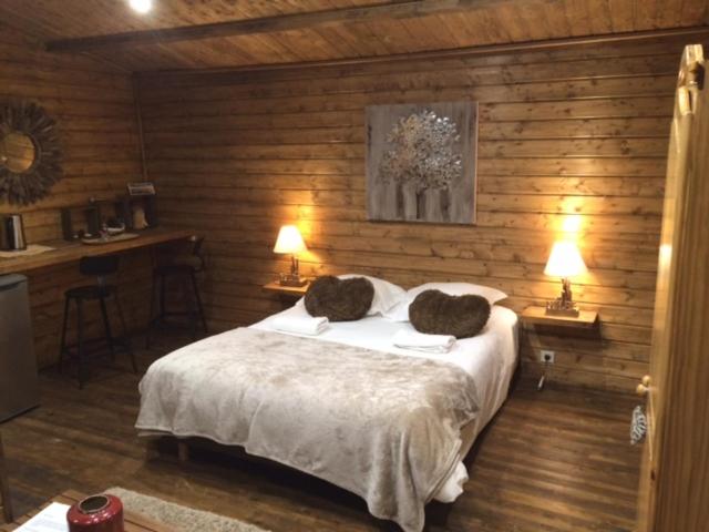 a bedroom with a bed with two pillows on it at Gîtes les Chalets Vezzani Spa in Vezzani