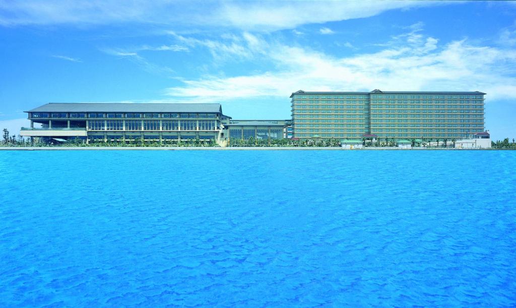 a large building next to a large body of water at Ryugujo Spa Hotel Mikazuki Ryugutei in Kisarazu