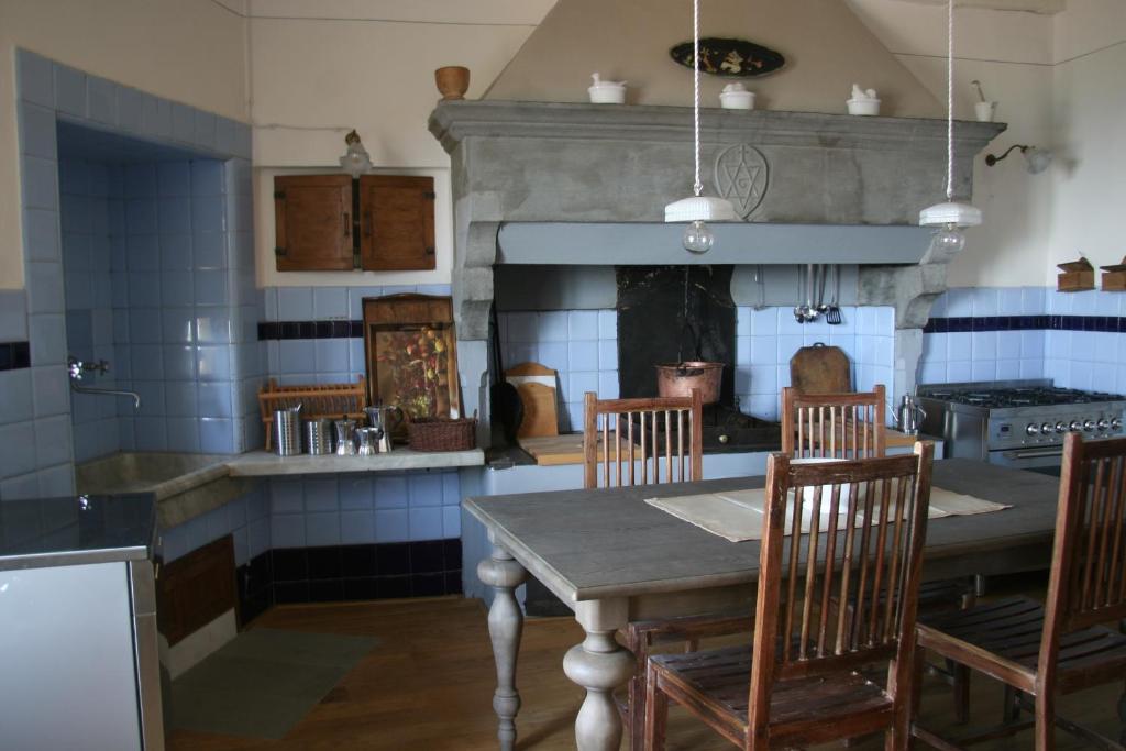 uma cozinha com uma mesa e cadeiras e uma lareira em Casa Ermenegilda em Cortona