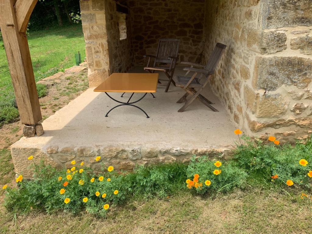 a table and chairs sitting on a patio with flowers at Gîte chez le Gaulois in Carsac-Aillac