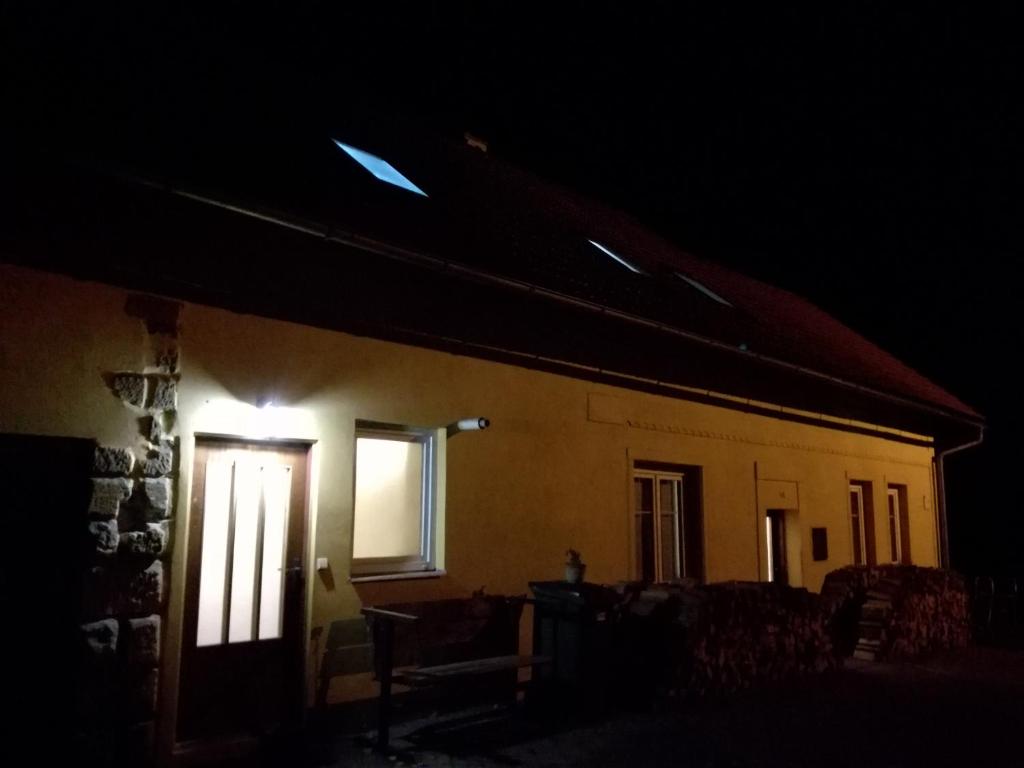 a house with a light on the side of it at night at MotoHostel Wolter - hostel Copa in Všeň