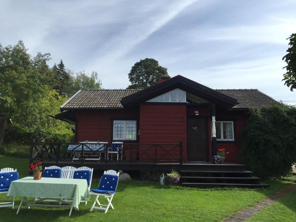 uma casa vermelha com uma mesa e cadeiras em frente em Ehlingården em Tällberg