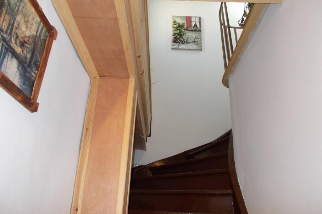a stairway with a white wall and wooden stairs at Square 's House in Lefkada