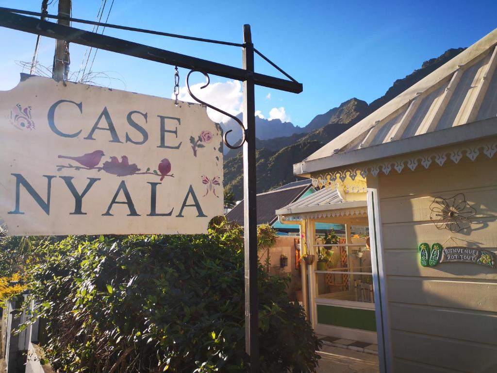 um sinal que lê caso nyrka em frente a um edifício em Case Nyala em Cilaos