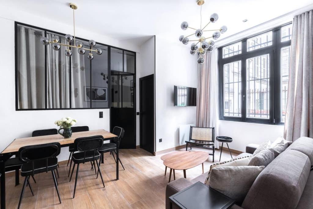 パリにあるHSH Amsterdam St-Lazare Luxury & Design Apartment 6P-2BRのリビングルーム(ソファ、テーブル付)