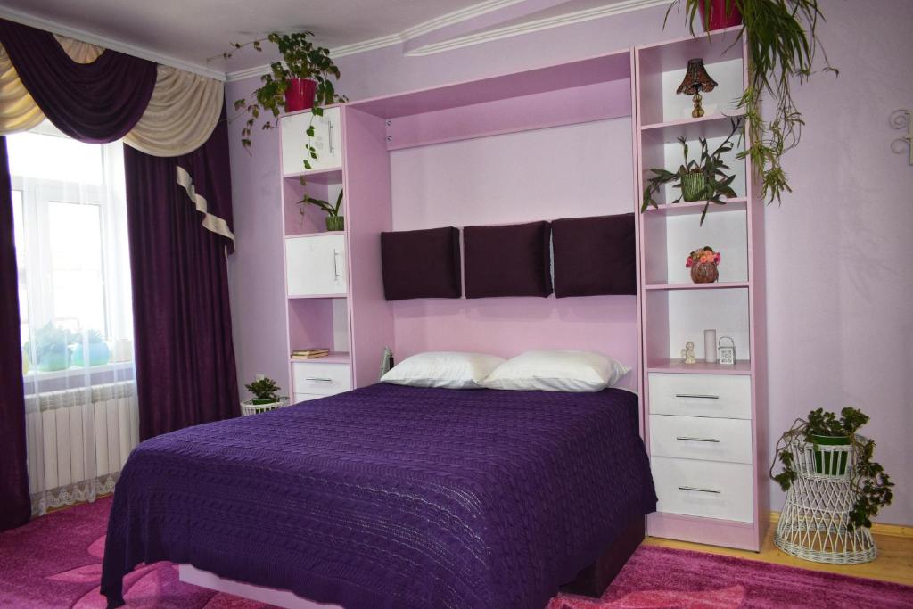 una camera viola con letto viola e scaffali di Apartments Provence a Černivci