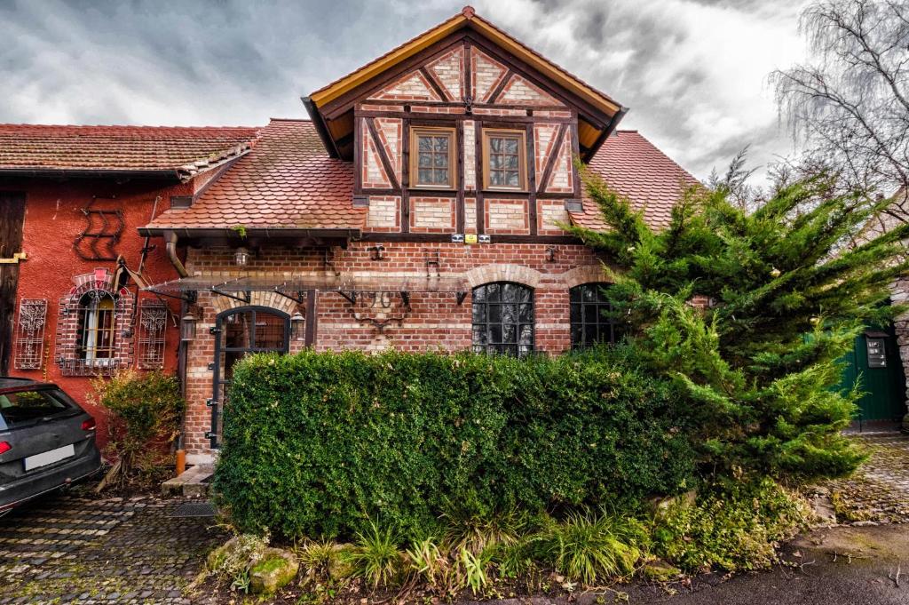 ein altes Backsteinhaus mit einem Baum davor in der Unterkunft Ferienhaus Alte Schmiede in Erfurt