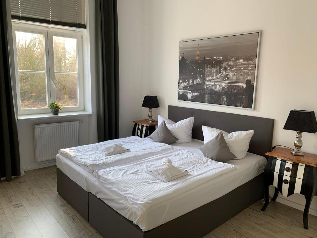 a bedroom with a large white bed with two windows at Parkhotel Putbus Superior International in Putbus