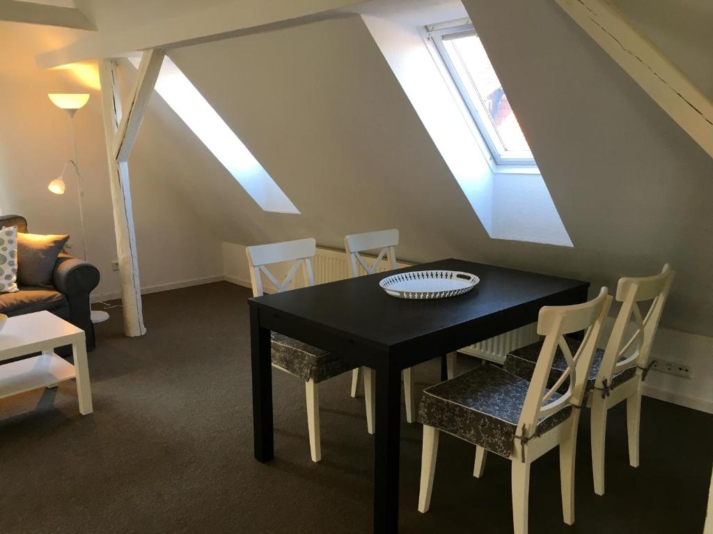 a dining room with a black table and chairs at Studio Emilie in Detmold