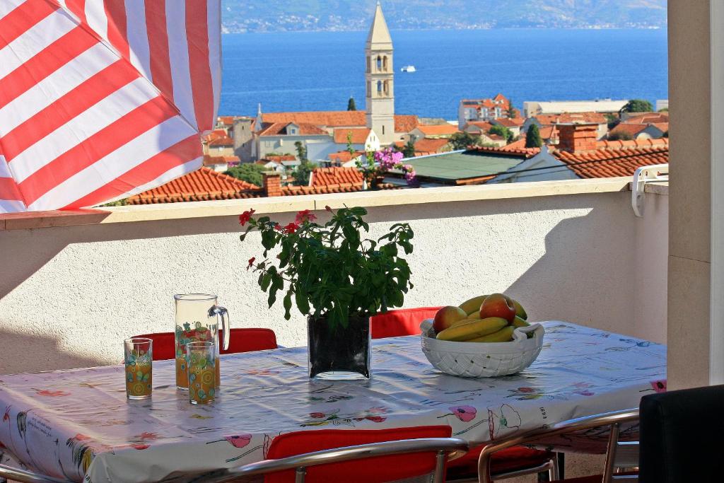 una mesa con un bol de fruta en el balcón en Apartments Jakšić - Žile, en Supetar