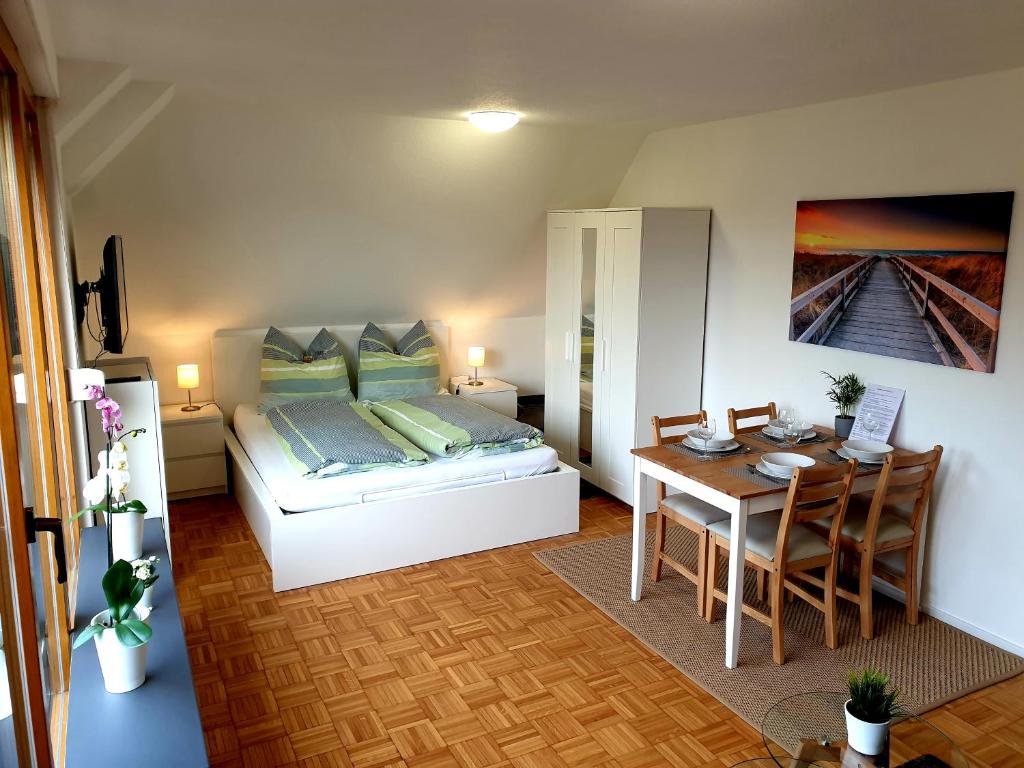 Habitación pequeña con cama, mesa y escritorio. en Wohlfühl-Apartment Bad Kissingen IV en Bad Kissingen