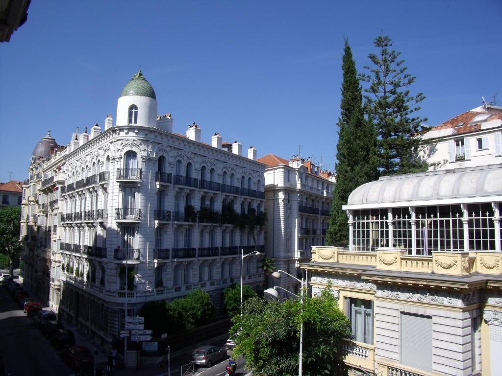 ein großes weißes Gebäude mit einem Turm darüber in der Unterkunft Nizza - Boutique Wohnung - near Hotel Negresco in Nizza