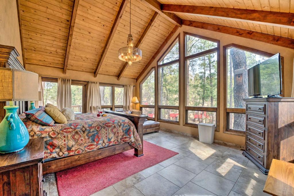 um quarto com uma cama, uma secretária e janelas em Central Ruidoso Mountain Home with Step-Free Access! em Ruidoso