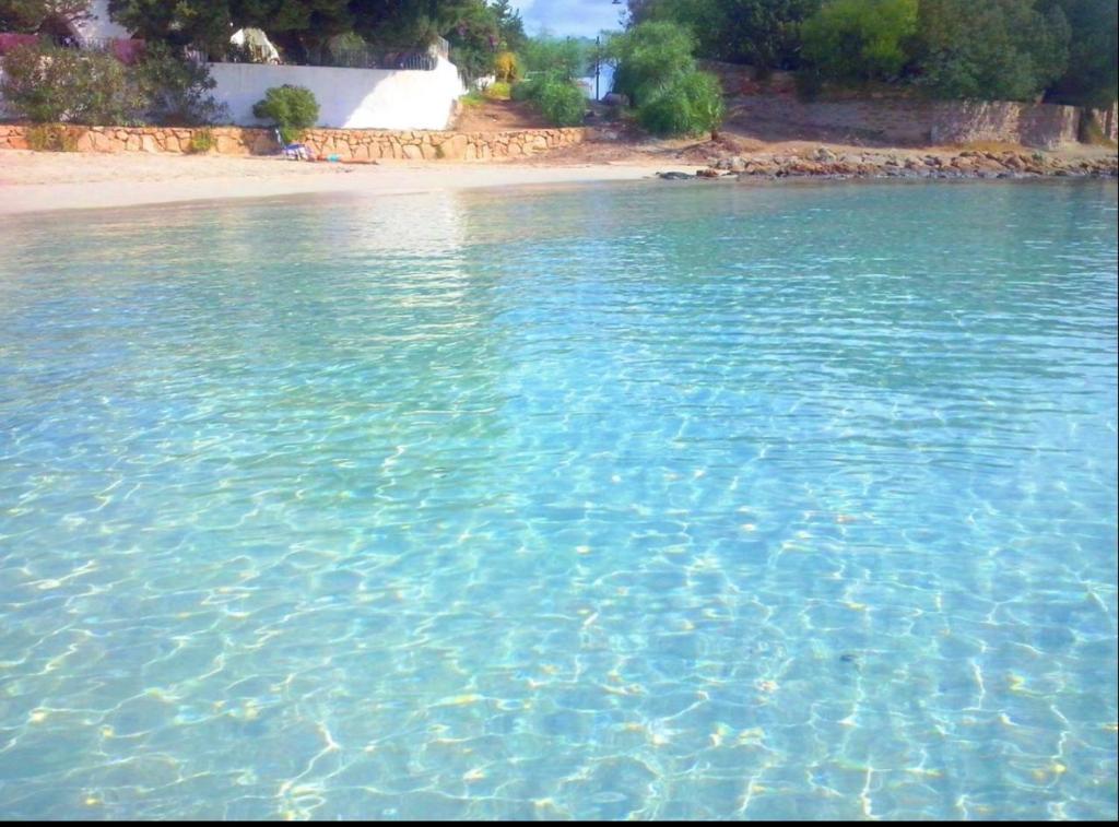 a large body of water with a sandy beach at I Tre Mari Luxury in Olbia