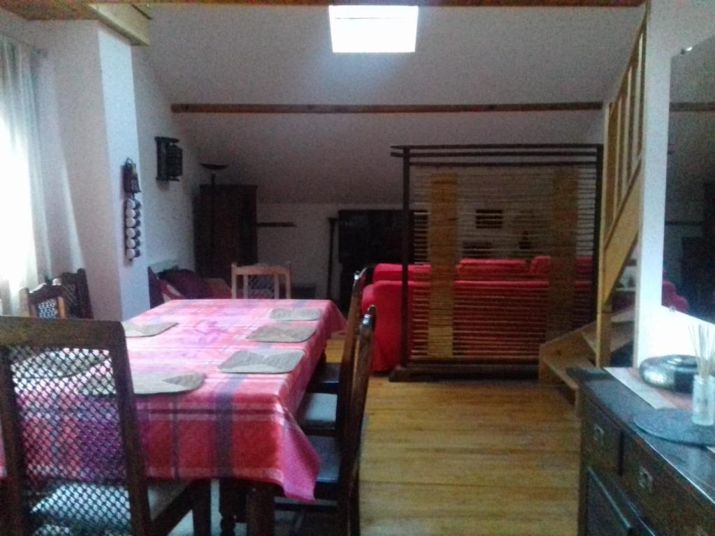 ein Esszimmer mit einem Tisch und ein Zimmer mit einem Bett in der Unterkunft Appartement en loft 50m2 dans maison avec chambre en mezzanine et canapes lits dans salon in Saint-Pierre-de-Chartreuse