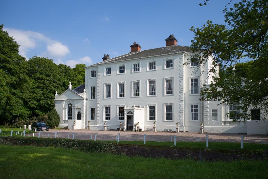 uma grande casa branca com uma entrada em frente em The Clock House em Brewood