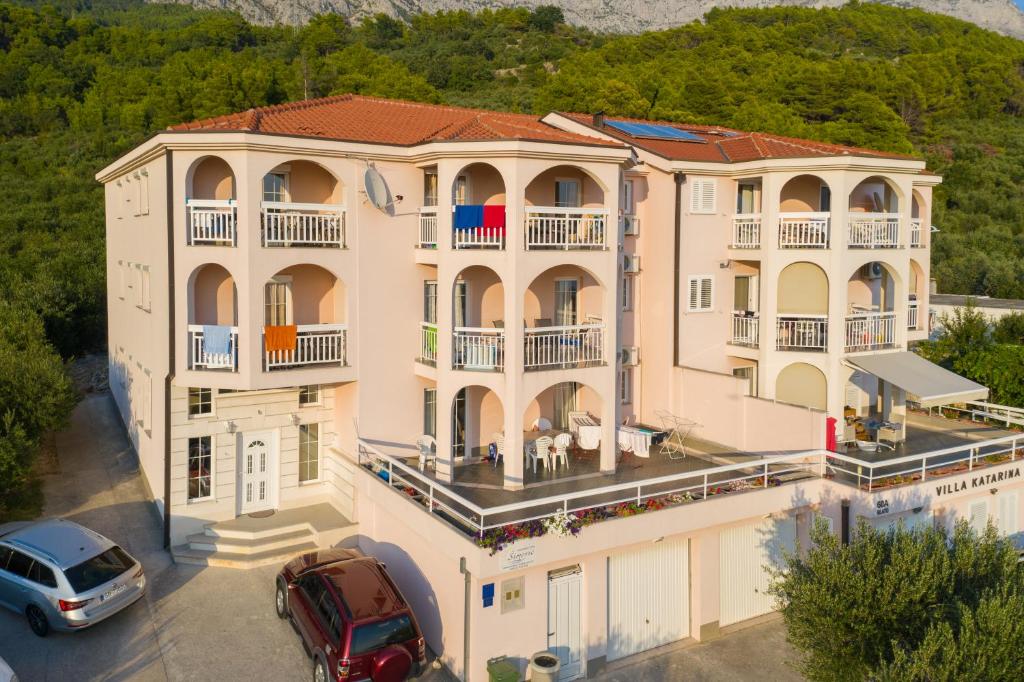 a large building with cars parked in front of it at Apartments Simovic in Tučepi