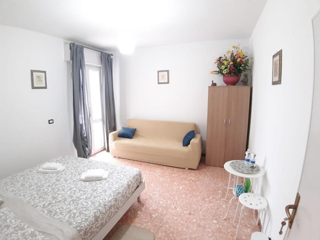 Kleines weißes Zimmer mit einem Bett und einem Sofa in der Unterkunft Sleep&Go airlines pisa in Pisa