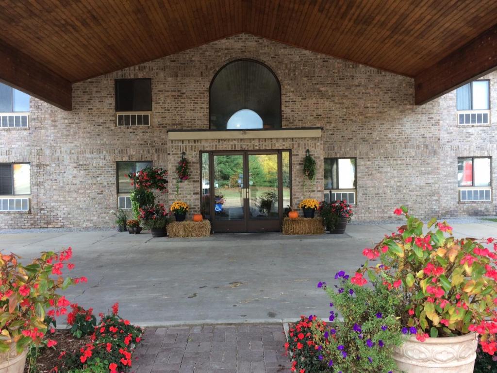 ein großes Backsteingebäude mit einer Tür mit Blumen in der Unterkunft All Seasons Resort in Kalkaska