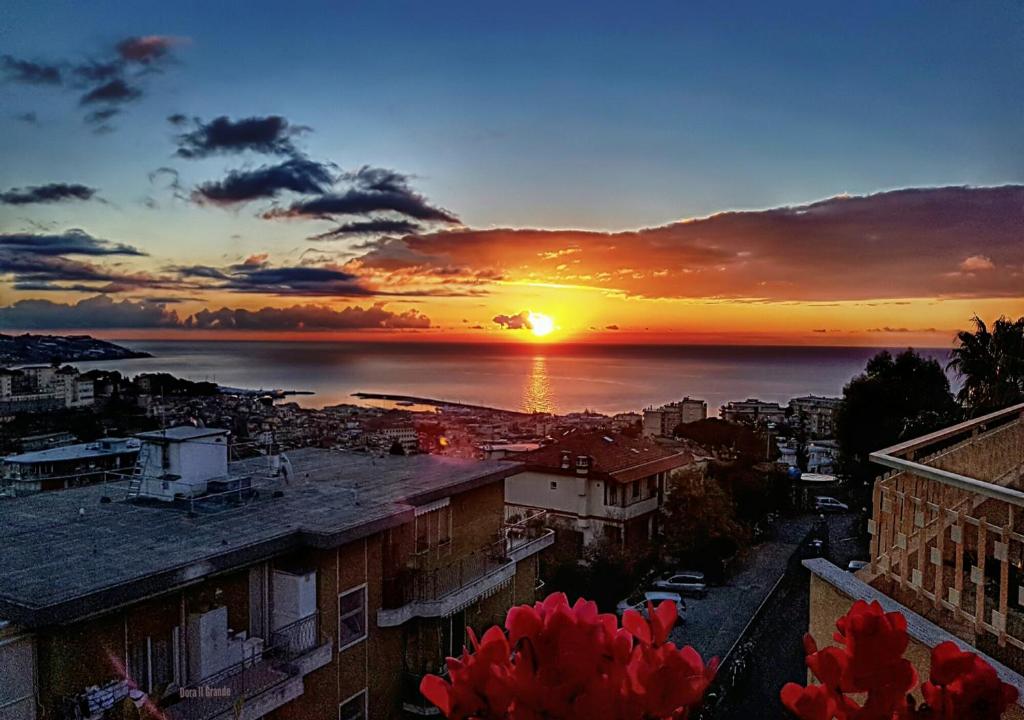 uma vista para o pôr-do-sol sobre uma cidade em Il Paradiso del Relax Chambres d'hotes Affittacamere room with sea view em Sanremo