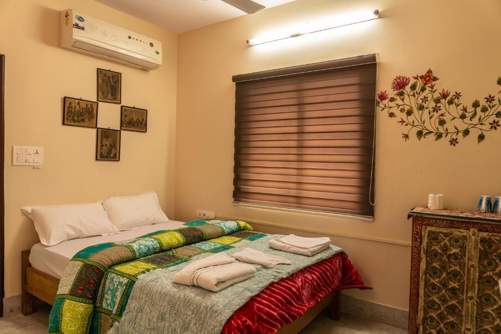 a bedroom with a bed and a window at Swiss House in Jodhpur