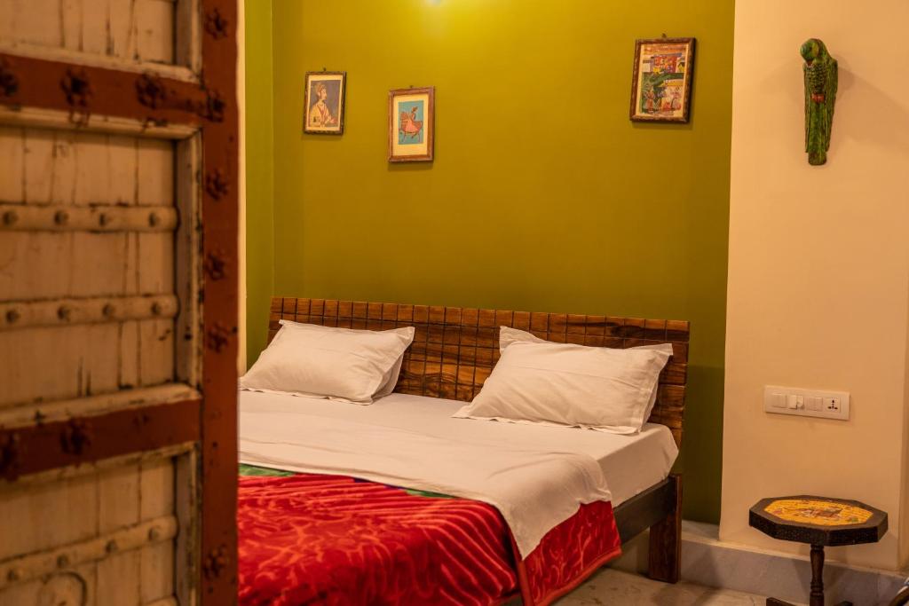a bed in a room with a green wall at Swiss House in Jodhpur