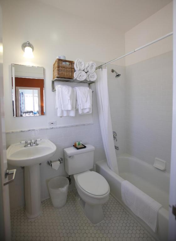 a white bathroom with a toilet and a sink at Venice Suites in Los Angeles