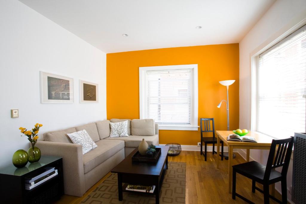 a living room with a white couch and an orange wall at Venice Suites in Los Angeles