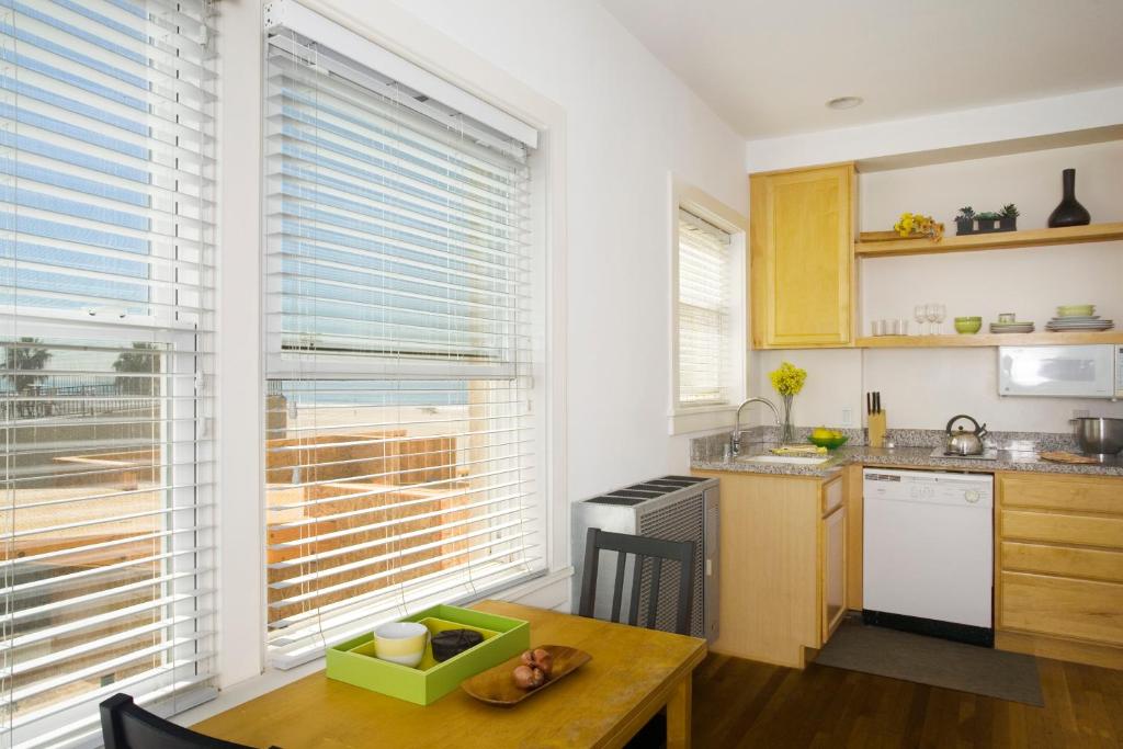 a kitchen with a table and a window with blinds at Venice Suites in Los Angeles