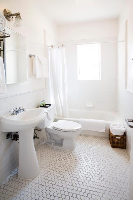 a white bathroom with a toilet and a sink at Venice Suites in Los Angeles